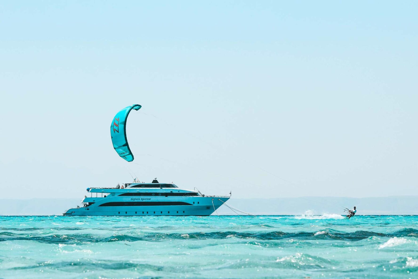 A kitesurfer and a luxury yacht on a Red Sea island in Egypt