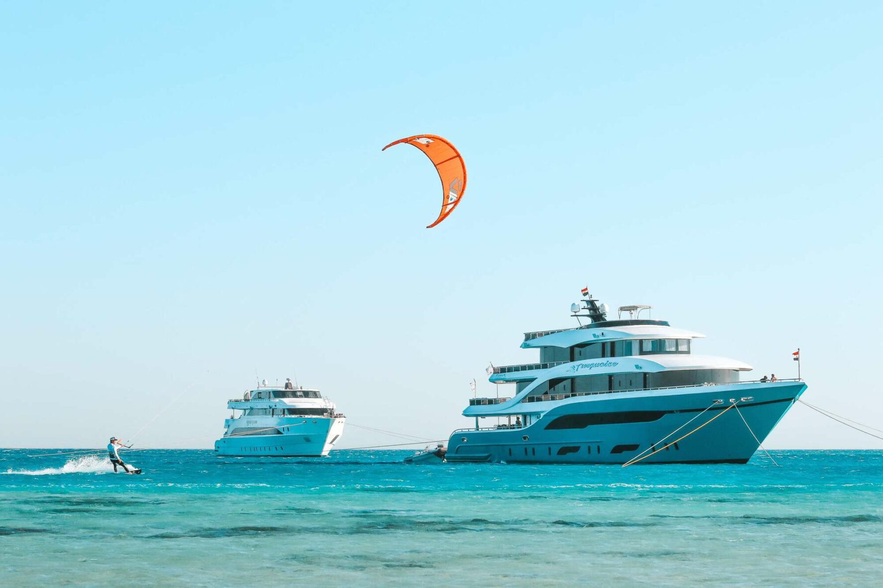A kitesurfer and two luxury yachts on a Red Sea island in Egypt