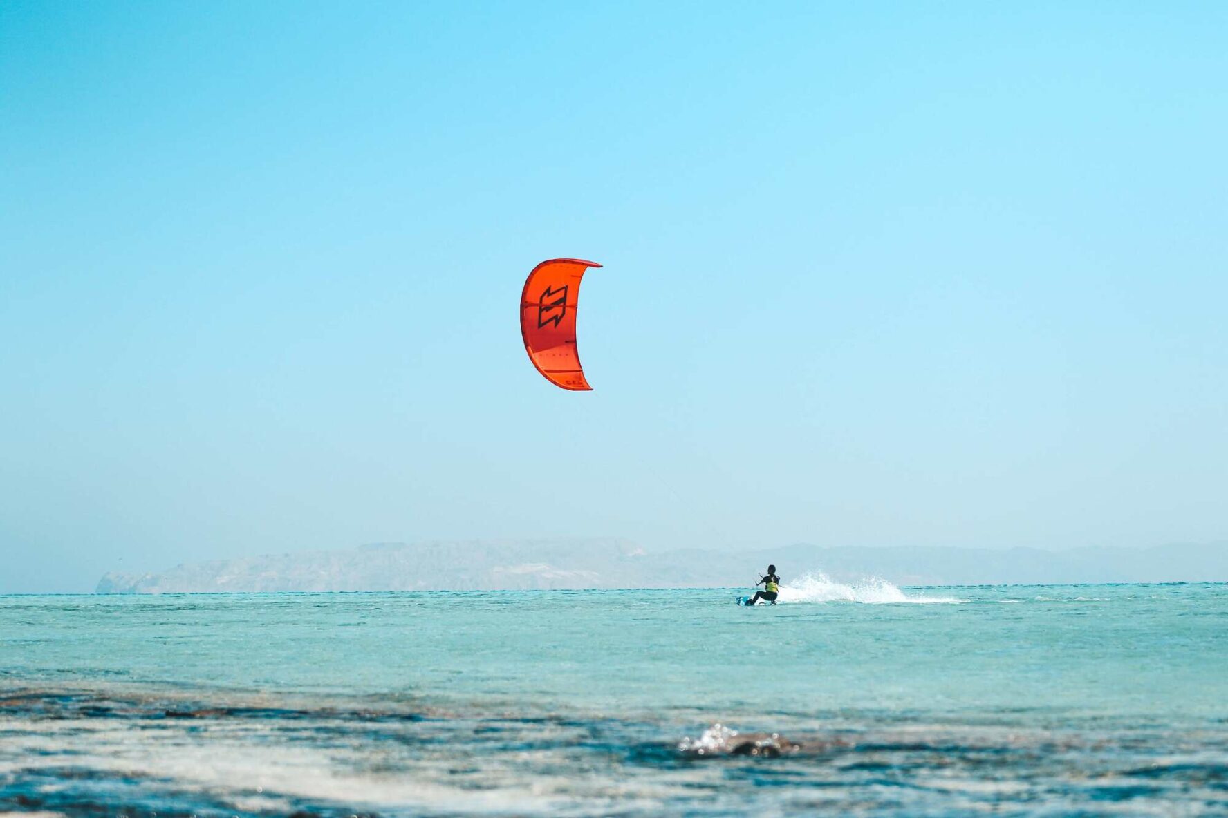 A kitesurfer shredding waves on an island in the Red Sea, Egypt