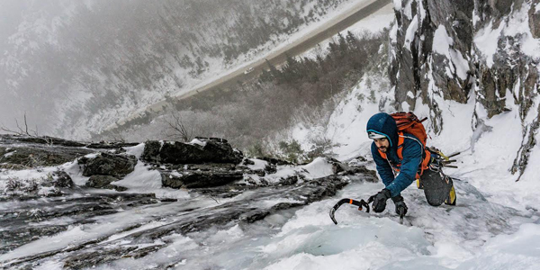 A man ascending an icy cliff in New Hampshire