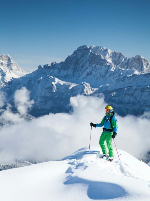 A skier and a tall mountain peak in the Dolomites