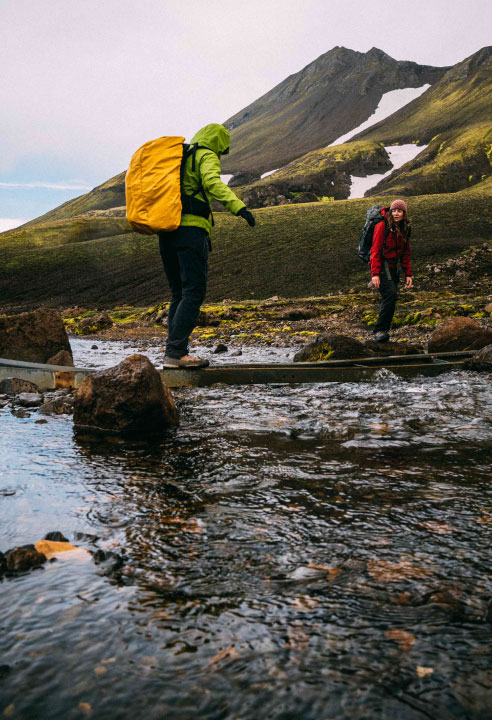 An Iceland tour group crossing a shallow river.