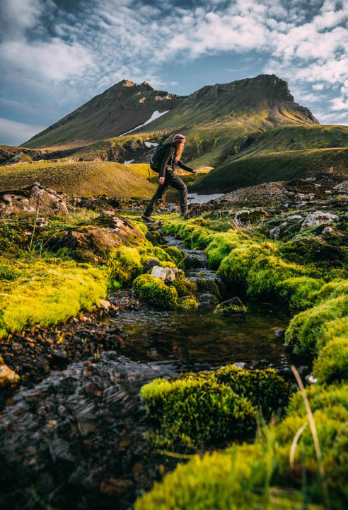 Woman hiking in the lush, mossy wilderness of Southern Iceland