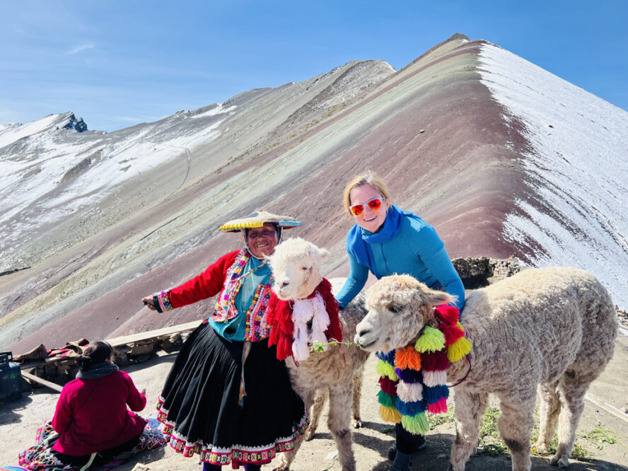 The local culture is tied to the alpacas, which are standing here backdropped by the Rainbow Mountain.