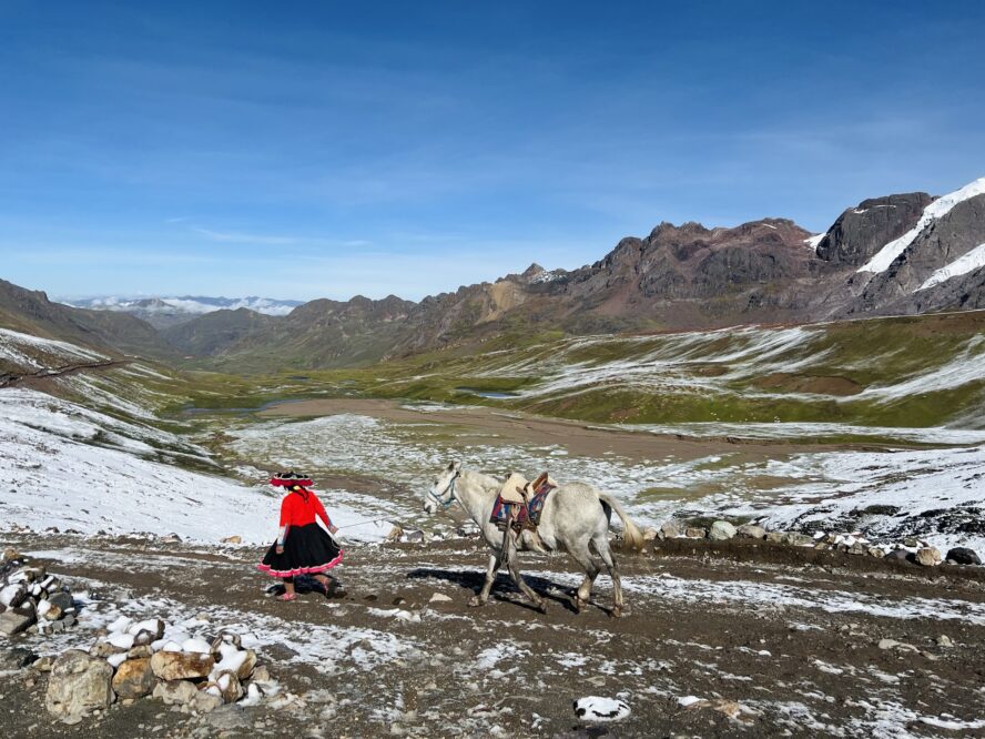 From the trailhead at the bottom, you can ride on horseback most of the way up Rainbow Mountain. Here, you see a local wearing traditional hojotas (or sandals) while leading a horse.