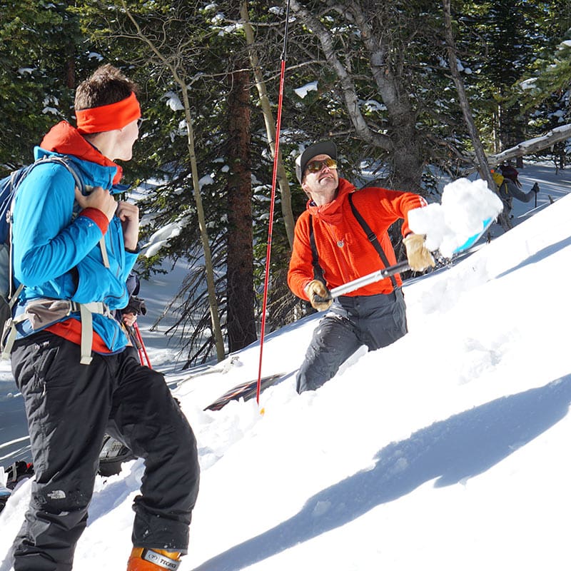 A backcountry skier shoveling snow during an AIARE Level 2 Avalanche Course in Estes Park