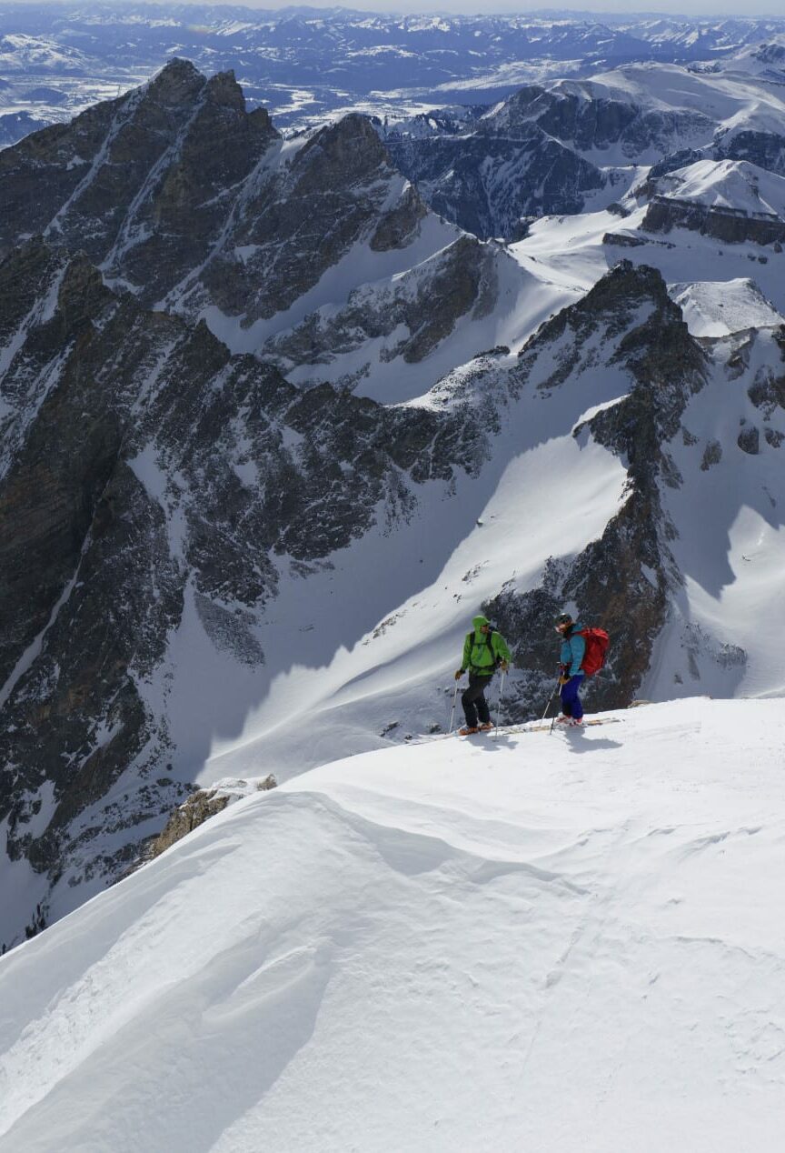 Skiers standing on a viewpoint in Teton Pass.