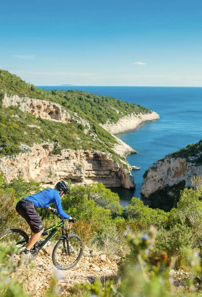 Mountain biker on a tour along the coast, overlooking a bay
