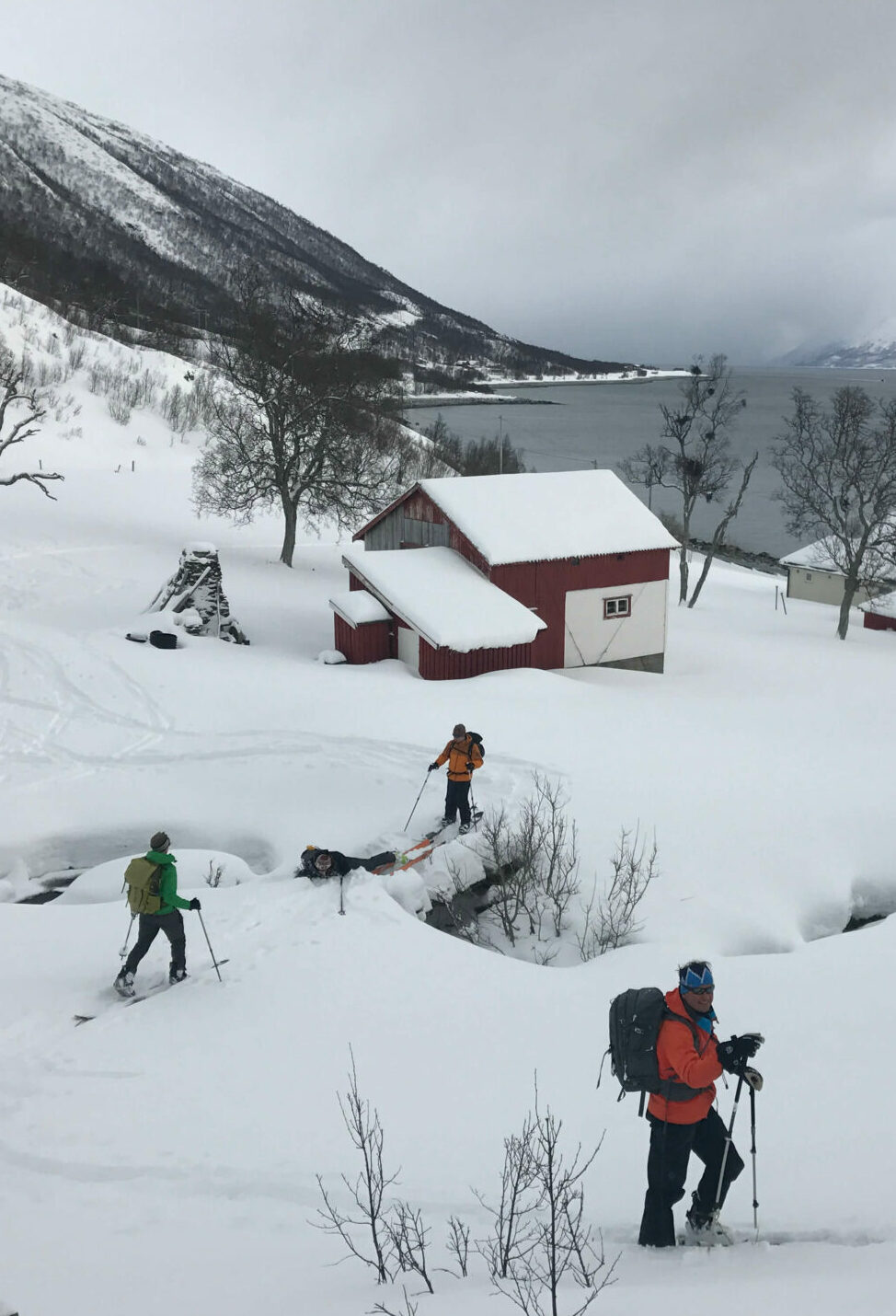 Skiers skinning through fishermen villages in Lyngen Alps