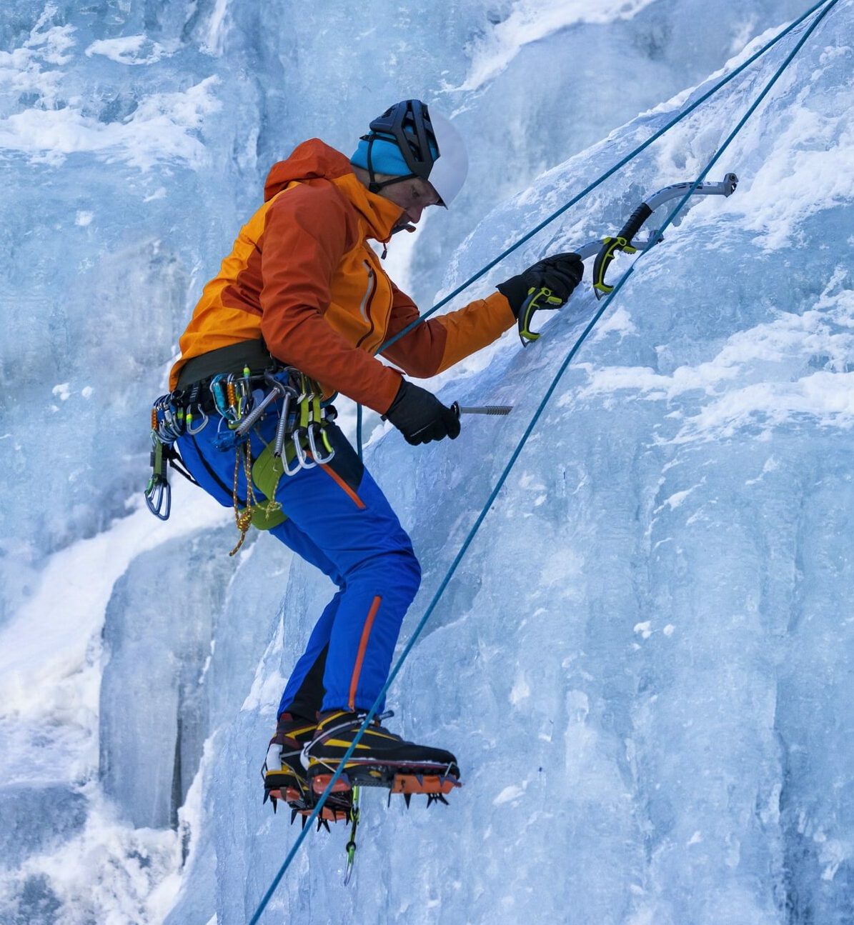 An ice climber navigates between rocks