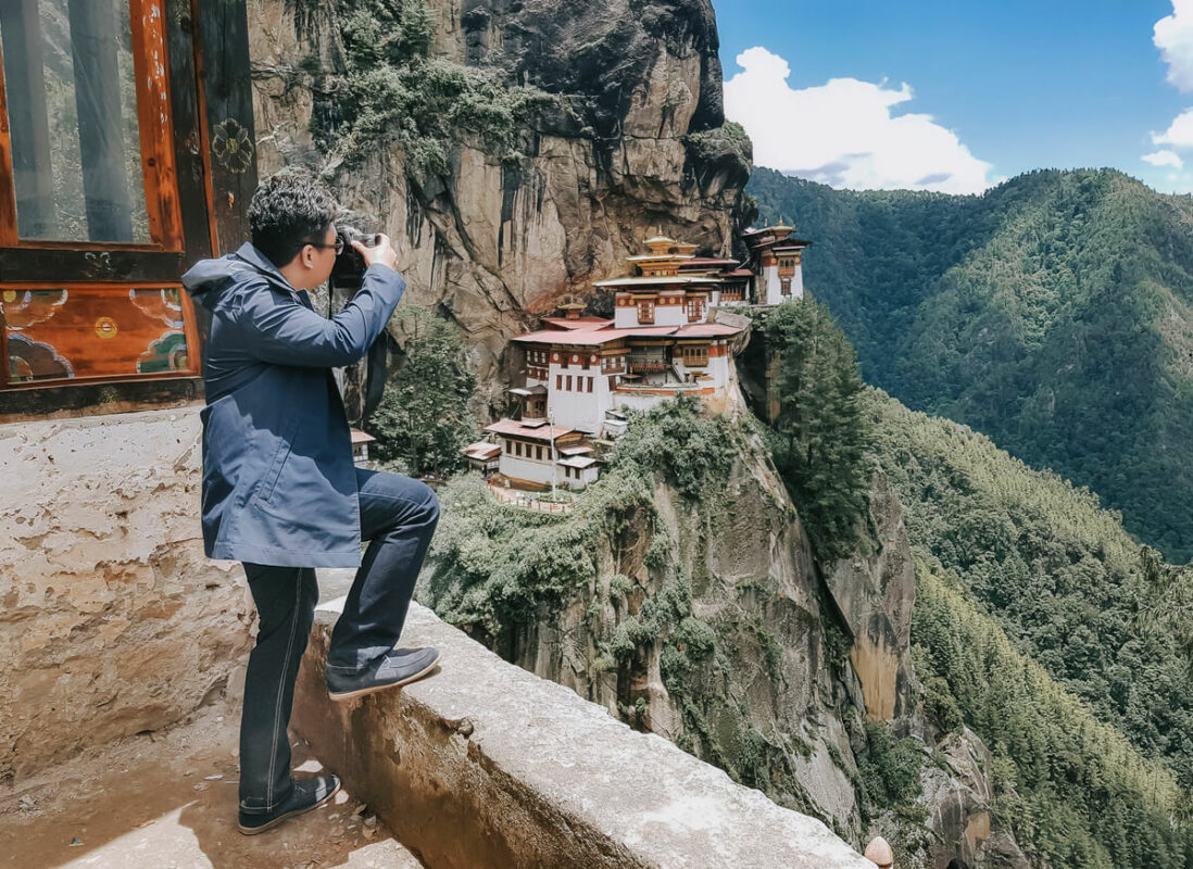 A tourist photographing Tiger’s Nest monastery in Bhutan