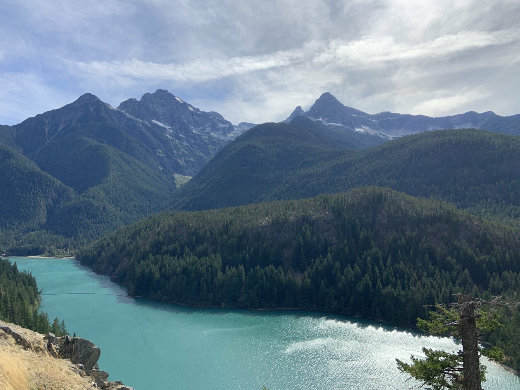 An alpine lake seen from a lookout in the North Cascades on a sunny summer day.