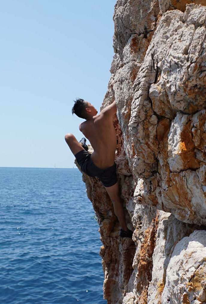 A man deep water soloing, Sun Sail Climb