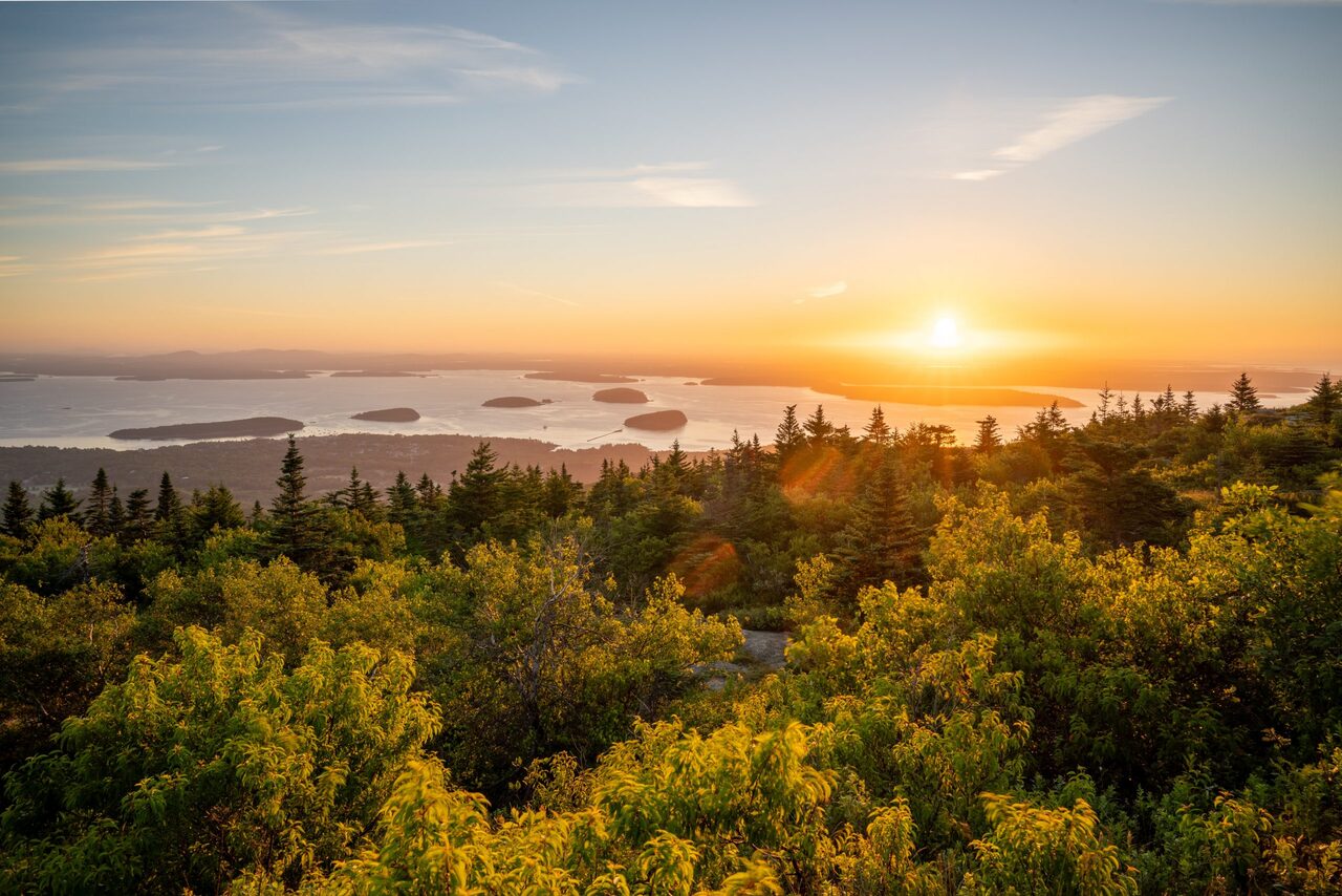 Sunset over the forests and shorelines of Acadia National Park.