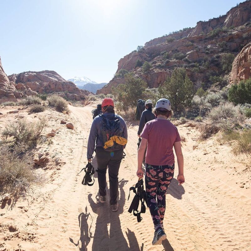 Climbers hiking to a route in Moab