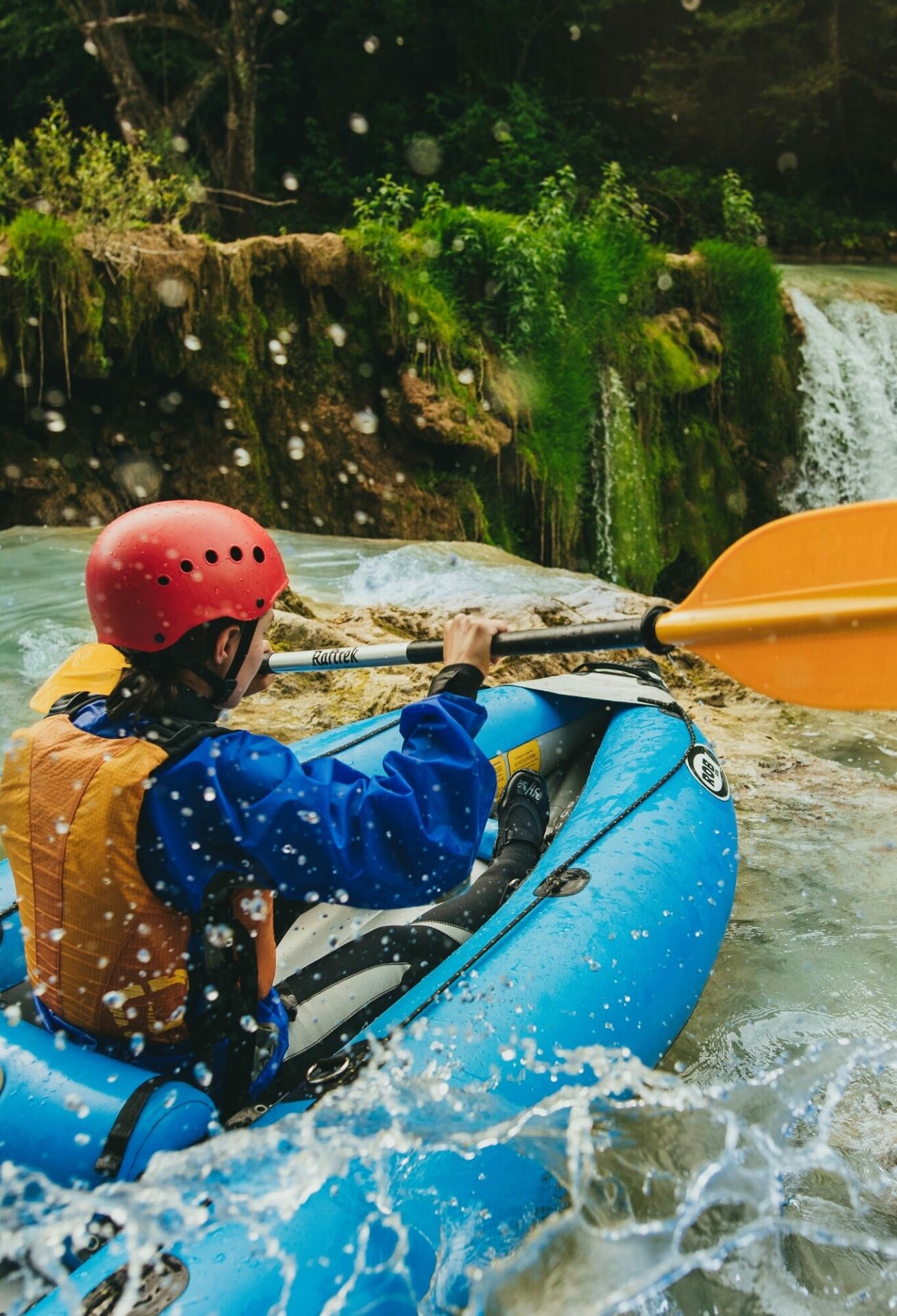 A person in a kayak/raft on river Mrežnica, going down a small waterfall