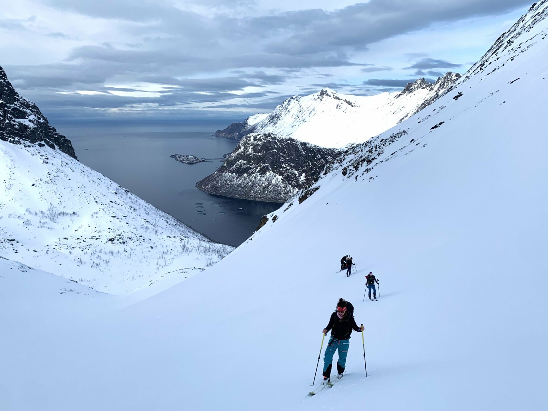 Skiers in a line climbing a mountain on skis
