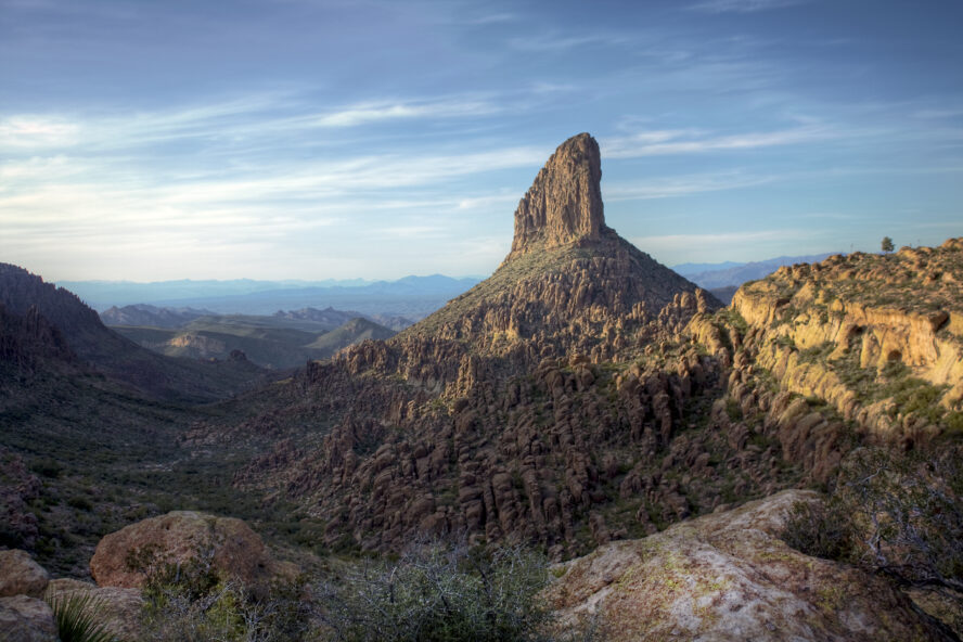  A tall fang-shaped rock rising out of the barren mountainous terrain in the Superstitions.