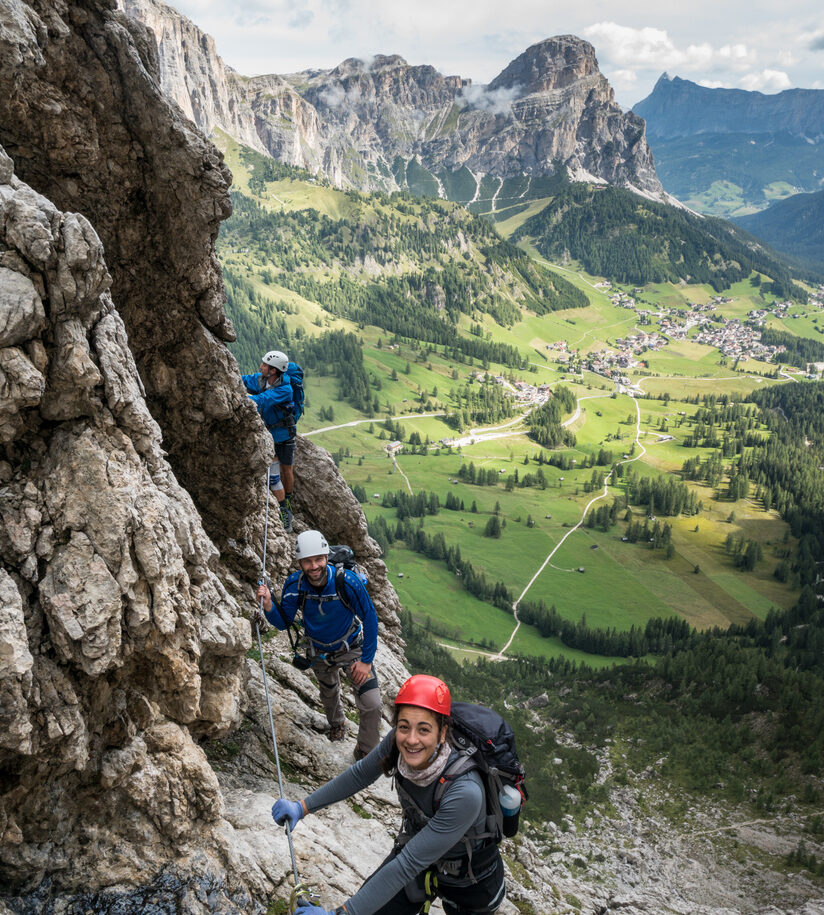 Three mountain climbers on a difficult Via Ferrata in the Dolomites in Alta Badia in the South Tyrol in Italy.