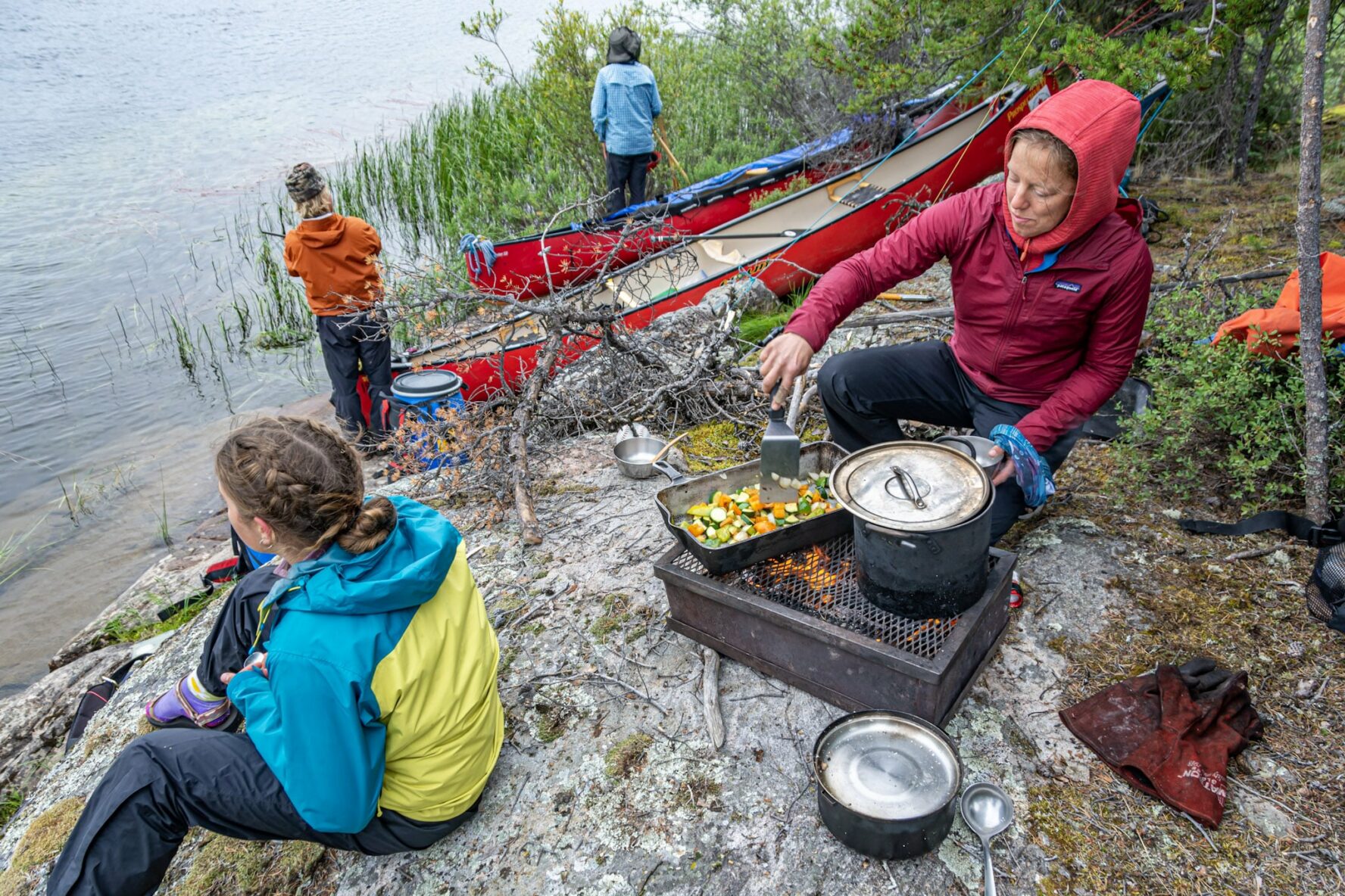 Canoers preparing food next to the Seal River in Manitoba