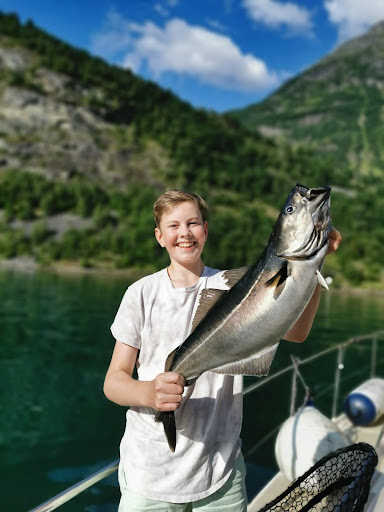 A child holding a fish on a sailing boat