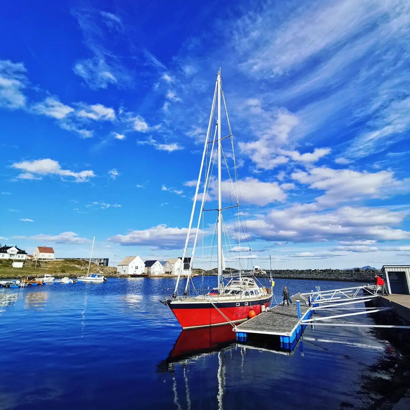 Men and a sailing boat in Runde, Norway