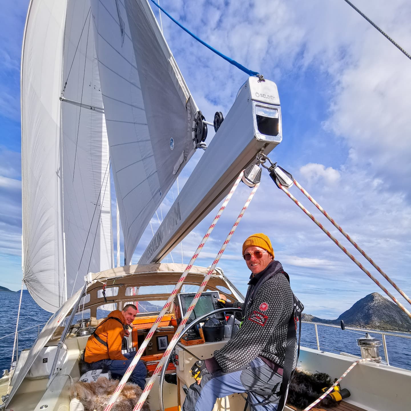 Men smiling on a sailing boat in Norway