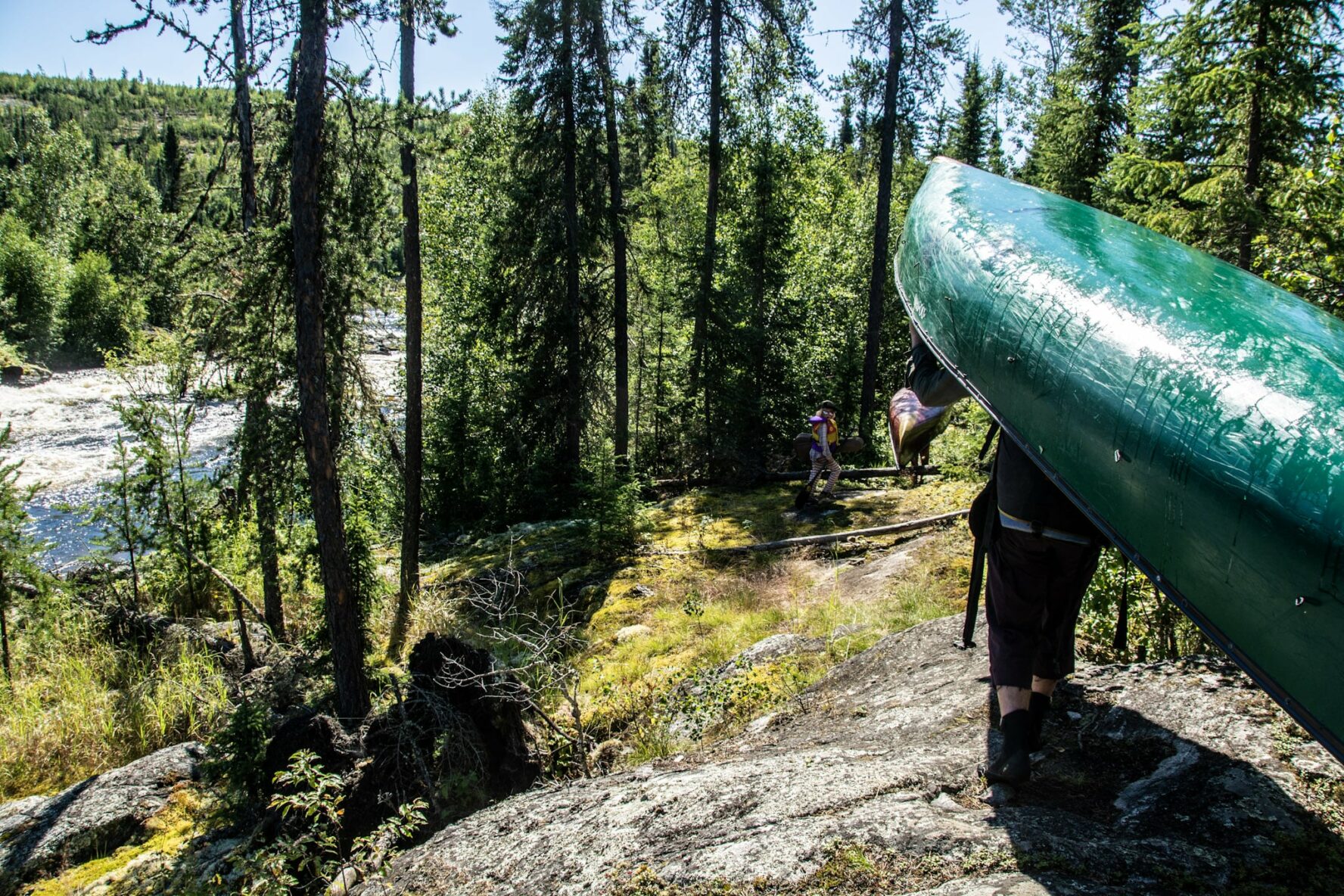 People carrying canoes on the Paull River