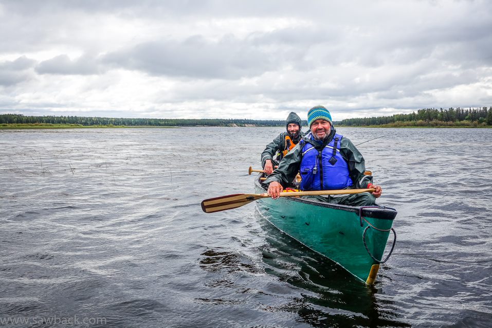 Two men smiling in a canoe on the Hawkrock River