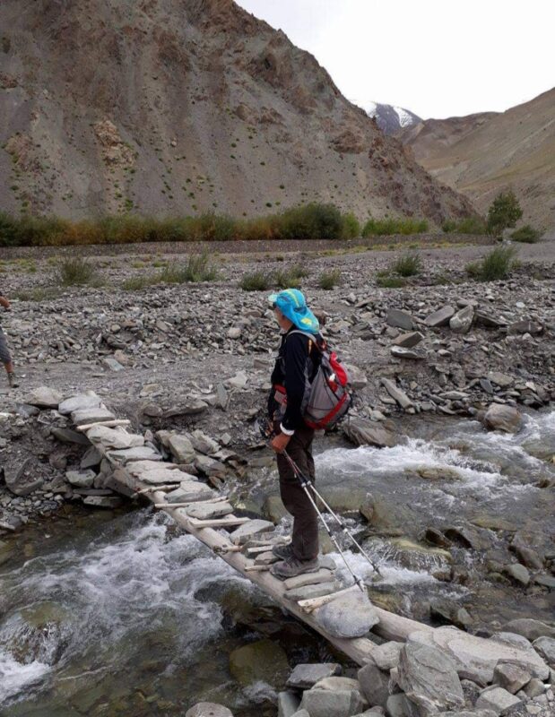 A hiker crossing a creek, the Sham Valley trek