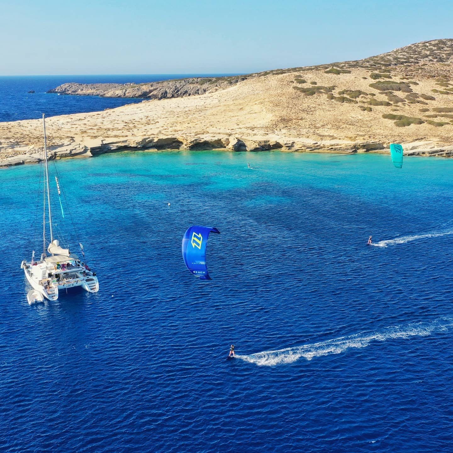 Kitesurfers and a catamaran in the Cyclades, Greece