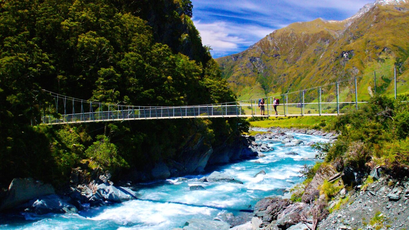 Hikers crossing swing bridge over Matukituki river