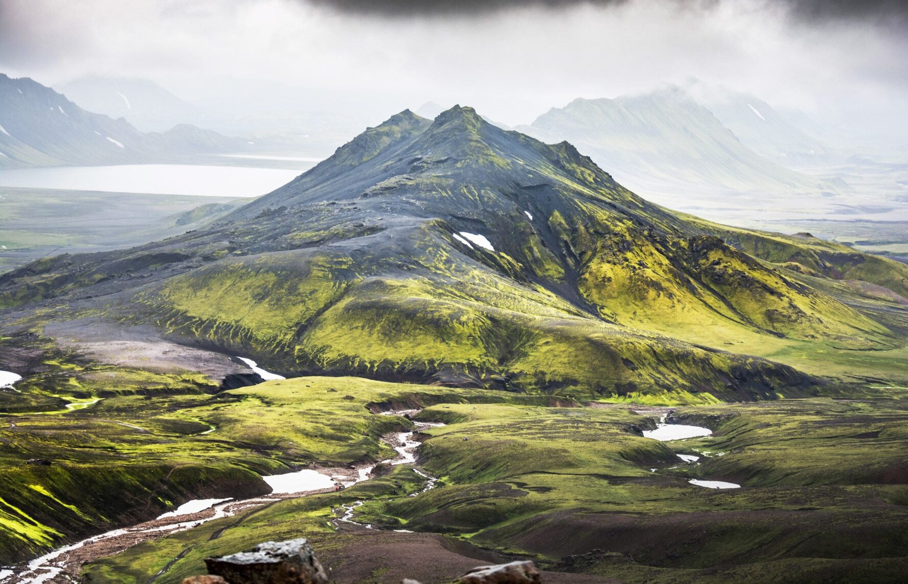Iceland's landscape is dotted with green mountains and volcanoes