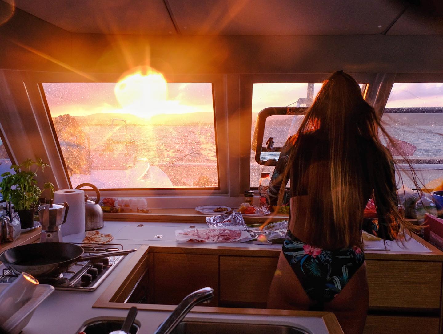A woman preparing food on a catamaran in Sardinia