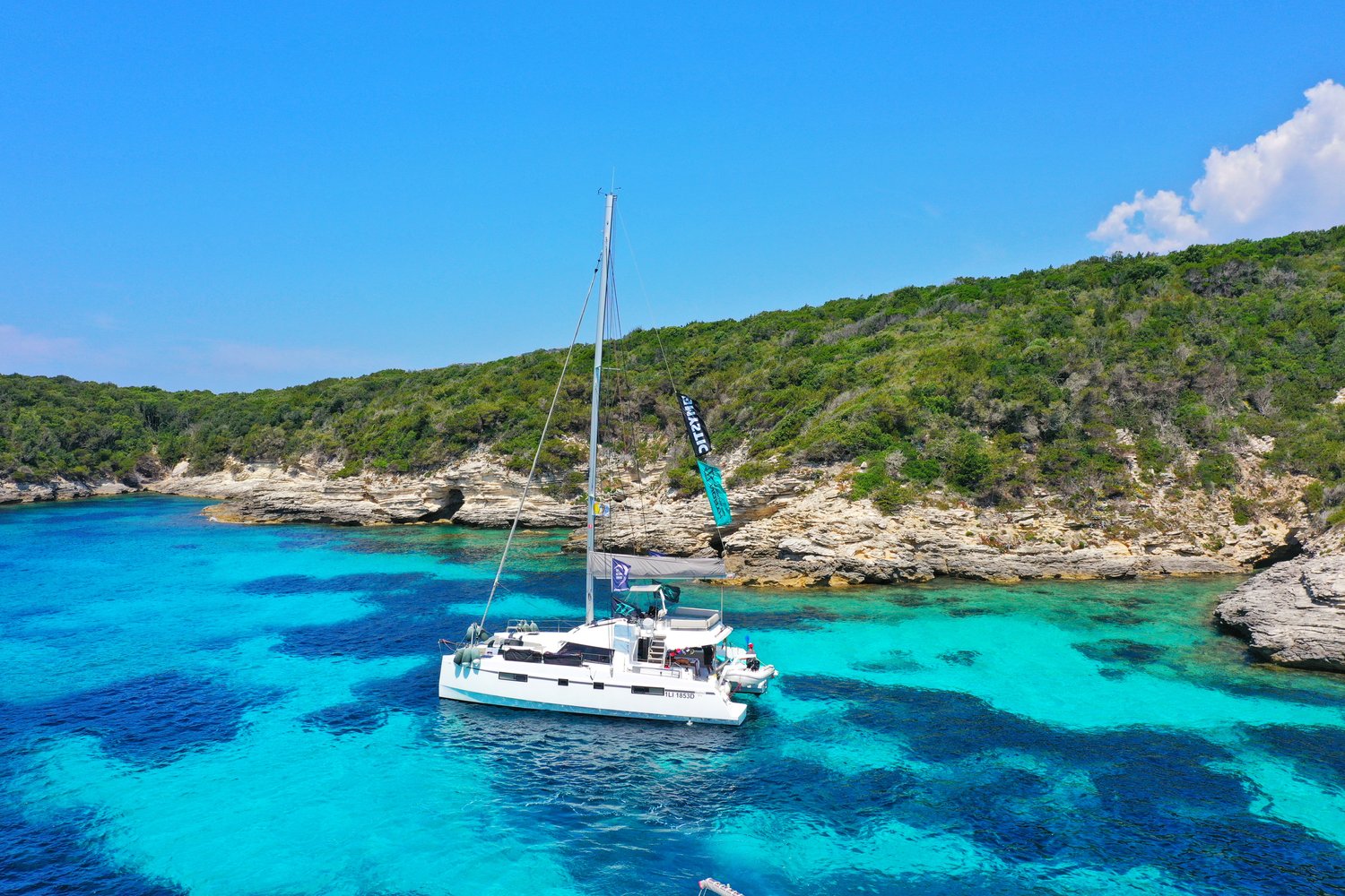 Catamaran in the middle of teal blue sea in Italy