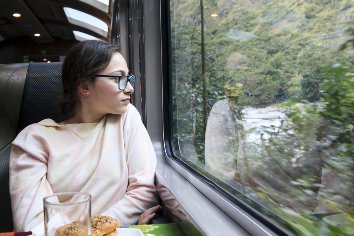 Young tourist girl travelling by train to Machu Picchu