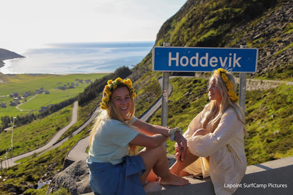 Girls posing in front of a sign for Hoddevik, Norway