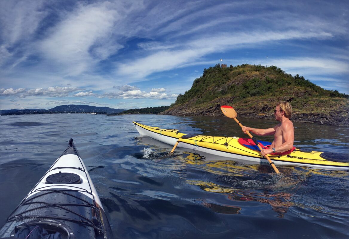 A man kayaking in the fjords of Norway