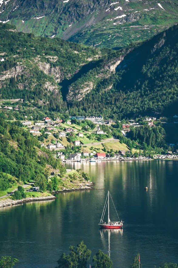 A sailboat near a scenic coastal town in Norway