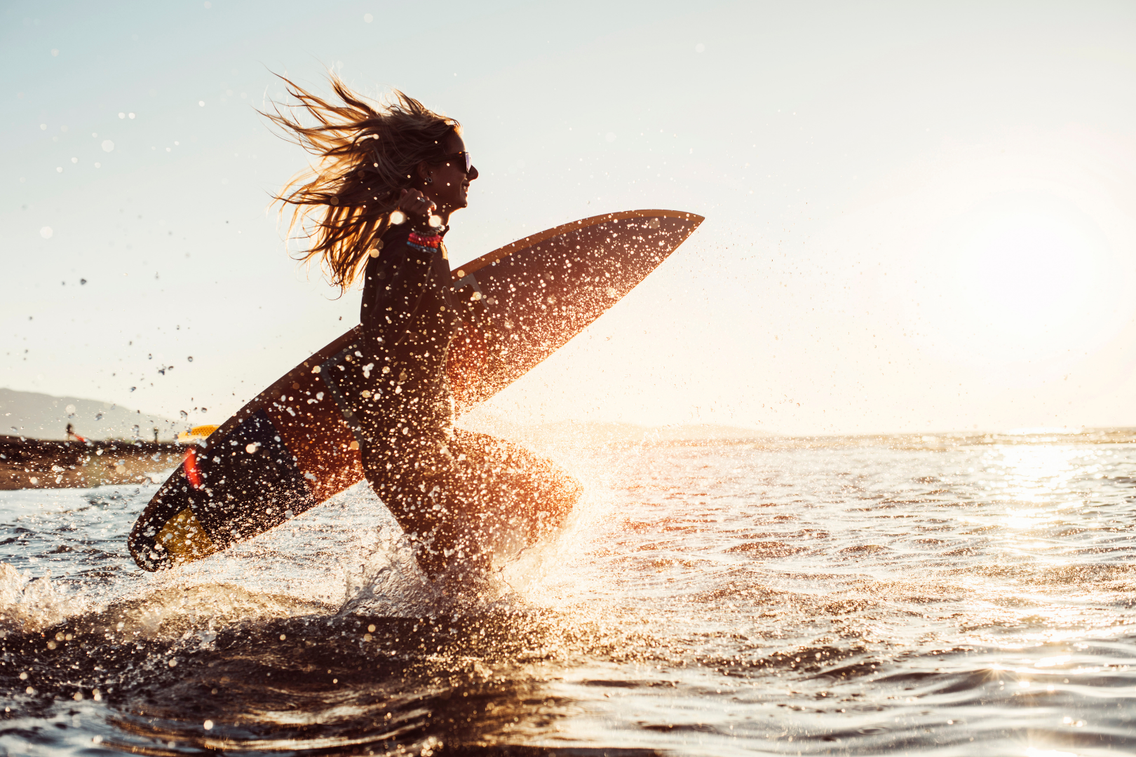 A surfer running through the water