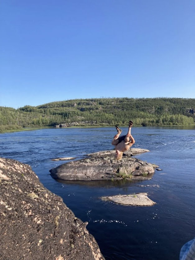 A boy jumping off a cliff at the Porcupine River