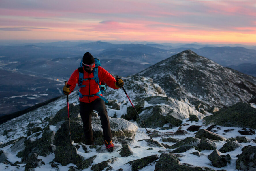 Hiker ascending a snowy and icy trail on the Presidential Traverse in winter.