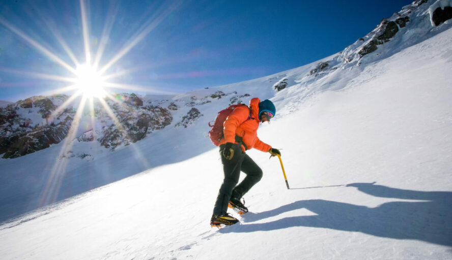 A mountaineer climbing Tuckerman Ravine on a bluebird winter day.