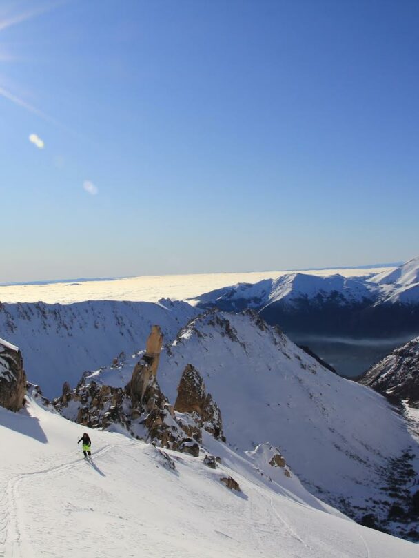 View of a frozen lake encircled by golden granite peaks close to refugio Frey.