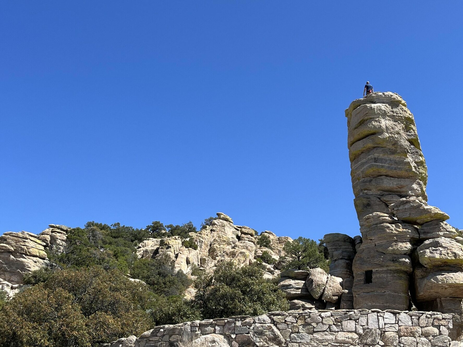 Climber atop a rock formation.