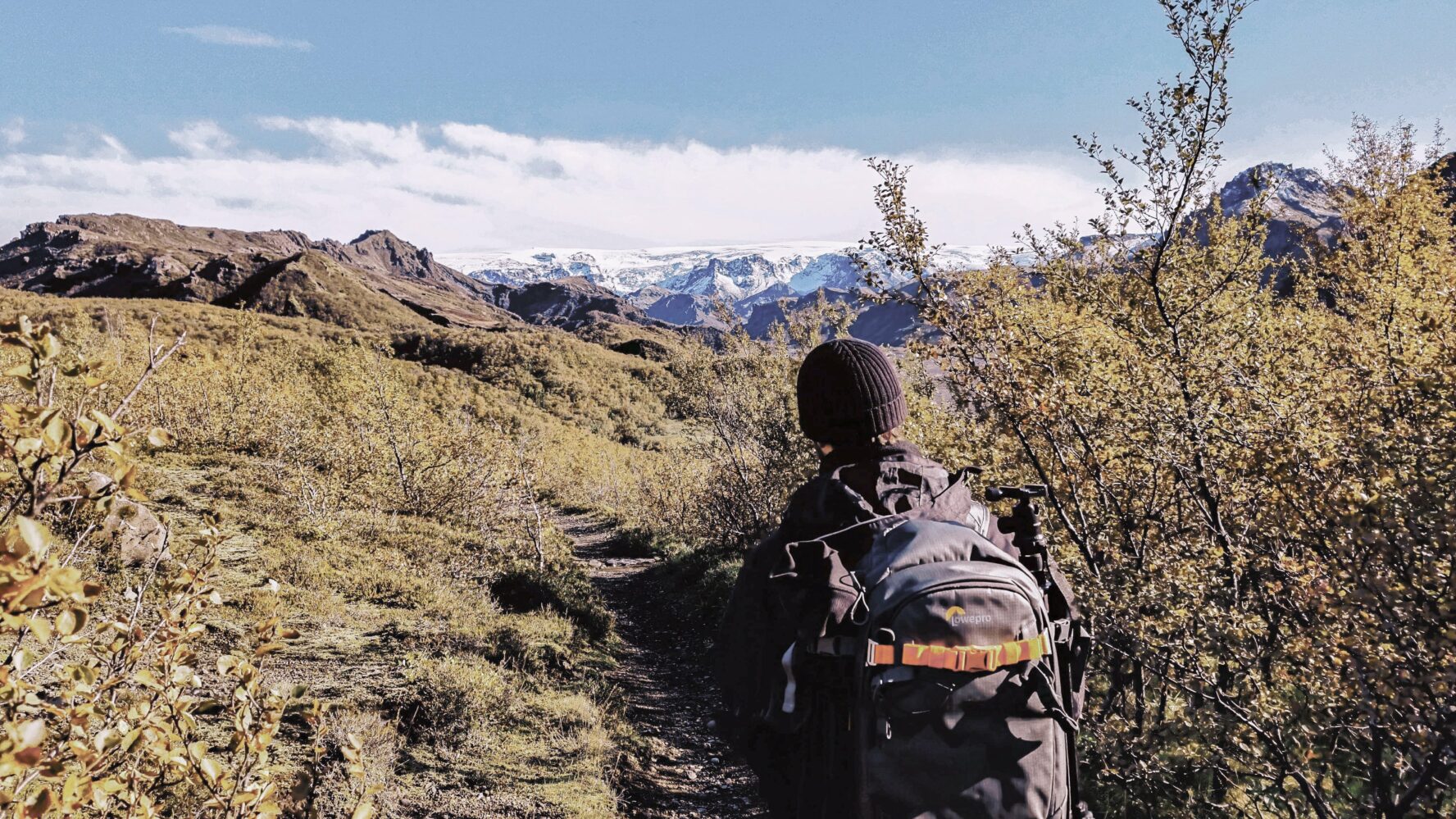 A hiker looking at the Myrdalsjokull glacier and Katla volcano in the distance