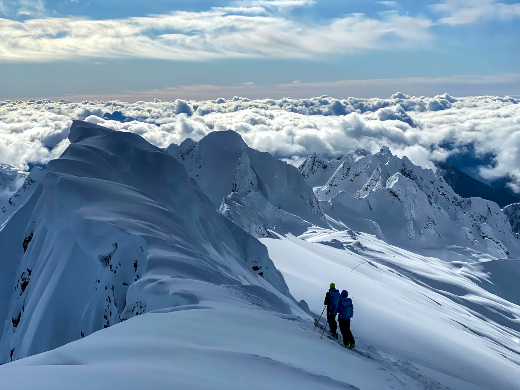 Skiers above the clouds.