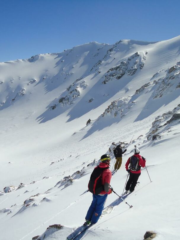 View of a frozen lake encircled by golden granite peaks close to refugio Frey.