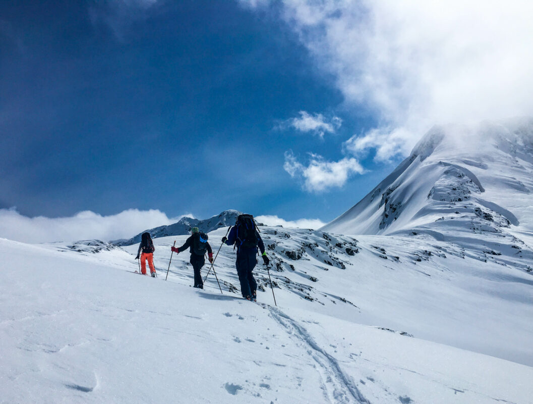 Three skiers going up the mountain