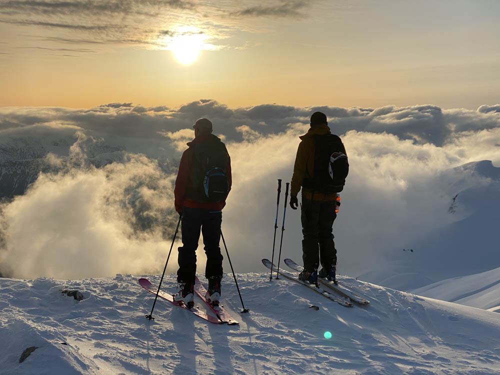 Two skiers standing above the clouds